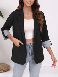 Détail d'un blazer noir cintré avec doublure rayée aux poignets et pattes boutonnées