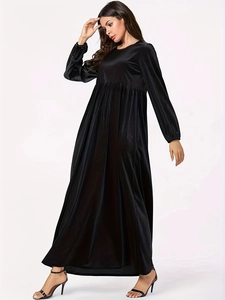 Detail of elegant black velvet long sleeve maxi dress with round neck and flared skirt