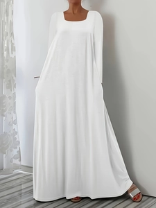 Détail d'une robe maxi blanche à col carré montrant les manches longues et la jupe fluide en A