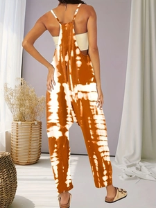 Detail of bohemian tie-dye jumpsuit with adjustable straps and relaxed fit in earth tones