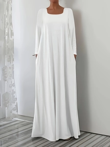 Détail d'une robe longue blanche à manches longues avec poches latérales et coupe en A