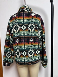 Detail of colorful ethnic geometric print on warm plush zip-up fleece jacket