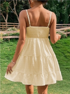 Dettaglio della schiena a punto smock e texture a pois su un abito estivo beige