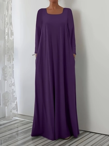 Détail d'une élégante robe longue violet foncé à col carré et manches longues évasées
