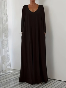 Detail view of the deep V-neckline and functional side pockets on this long black maxi dress
