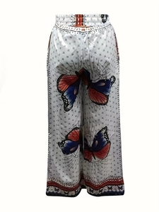 Detail of high-waist drawstring wide-leg pants with vibrant butterfly print and wavy hem