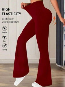 Detail view of high-waist flared yoga pants showing superior elastic stretch and dark red fabric