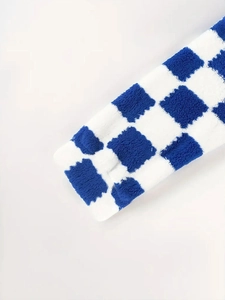 Detail von weichem blau-weißem kariertem Plüschstoff an einer Fleecejacke