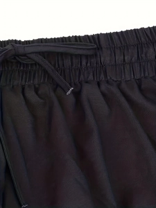 Detail of high-waist black casual pants with elastic waistband and adjustable drawstring