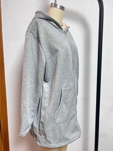 Detail view of long grey zip-up hoodie featuring warm fleece lining and front pockets