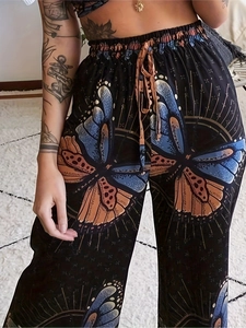 Detail of high waist floral wide leg trousers with orange butterfly print and drawstring