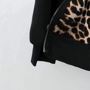 Detail of metal zipper closure on casual black jacket with stylish leopard print lining