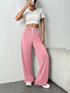 Detail of pink wide leg joggers featuring elastic drawstring waist and relaxed fit design