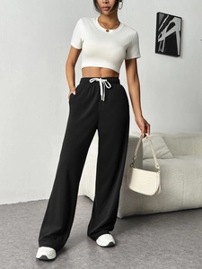 Detail of high waist elastic waistband with white drawstring on black wide leg trousers