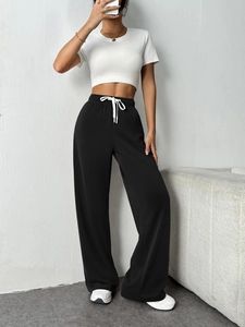Detail of high waisted drawstring wide leg sweatpants with white contrast drawcord