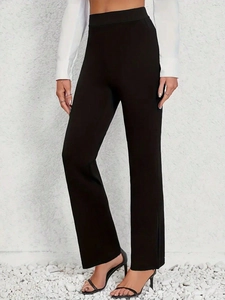 Detail showing high-waisted black flare pants with a slim fit and elegant drape
