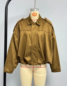 Dettaglio del bomber in pelle scamosciata marrone con spalle scese e spalline decorative