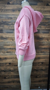 Close-up of pink knitted hooded cardigan featuring soft fluffy texture and ribbed cuffs