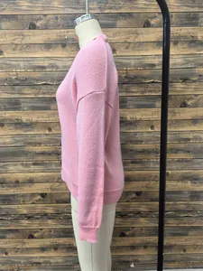 Detail of pink knitted cardigan showing ribbed cuffs and soft textured fabric texture