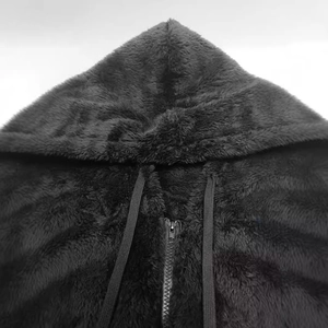 Detail shot of black fuzzy fleece material with metal zipper and drawstring hood