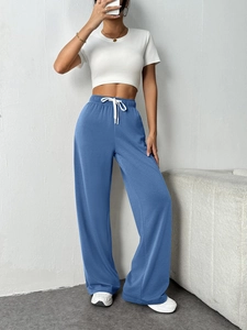 Detail of high-waist wide-leg lounge pants in fog blue with adjustable white drawstring