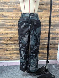 Detailed view of high-waisted camo cargo pants with side flap pockets and utility design