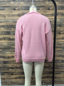 Rear view of pink knit cardigan showing ribbed cuffs and drop shoulder seam detail