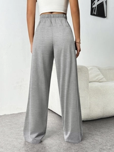 Detail view of high waisted elastic waistband on grey wide leg trousers for women