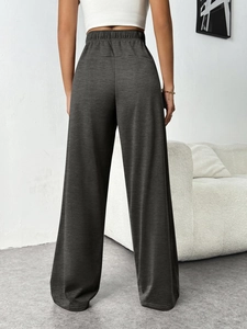 Detail view of high-waist elastic waistband on dark grey knit wide-leg lounge trousers