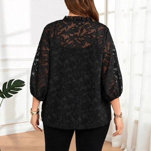 Detail der eleganten schwarzen Spitzenbluse mit transparentem Blumenmuster und Ärmeln