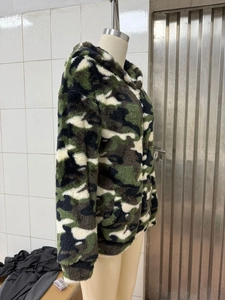 Close-up of camouflage fuzzy hoodie fabric with metal zipper on a female mannequin