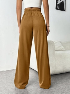 Detail view of mustard wide-leg lounge pants with elastic waist from a back perspective