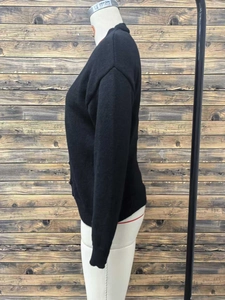Detailed close-up showing the fine knit texture and ribbed cuff of this black cardigan
