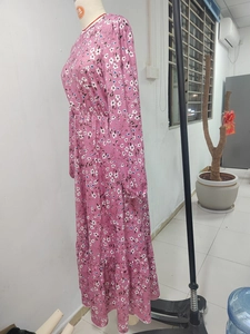 Detail of floral print pattern on a long-sleeved dress with waist elastic and ruffled hem