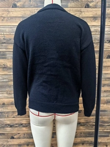 Back view of a black knitted cardigan featuring a lapel collar and ribbed hem details