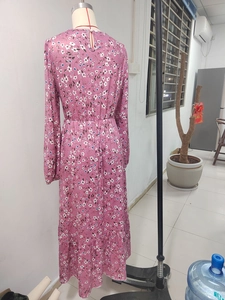 Detail of pink floral long sleeve dress showing high waist smocking and back button closure