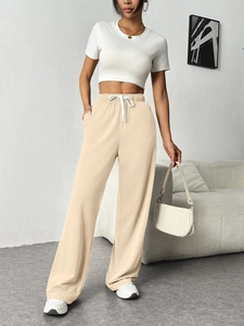 Detail view of high-waist apricot wide-leg sweatpants with drawstring and side pockets
