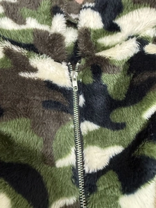 Close-up of camouflage pattern plush jacket featuring a durable metal zipper detail