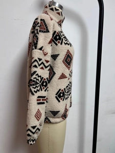 Detail of vintage ethnic print fleece jacket featuring rust red geometric patterns