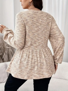 Side view of long sleeve peplum top in oatmeal knit texture with ruffled hem detail
