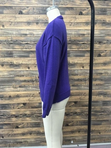 Detail of dark purple knitted cardigan with ribbed cuffs and side button closure