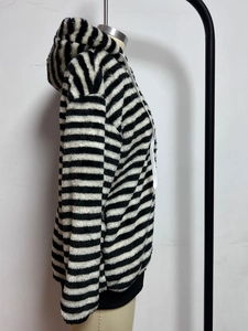 Detail of hooded faux fur jacket featuring black and white stripes and white drawstring