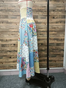 Detail of smocked elastic bodice and multi-pattern floral patchwork on a bohemian skirt