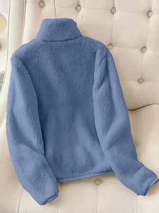 Détail du tissu en fausse fourrure bleue sur une veste élégante à col montant