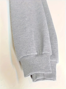 Nahaufnahme von grauem Kapuzenpullover-Stoff mit elastischen Rippbündchen und Strick