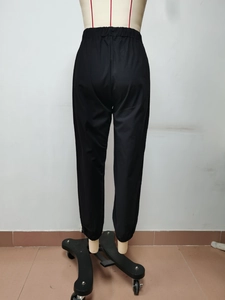 Dettaglio della vita alta elastica e del tessuto nero liscio di questi pantaloni jogger