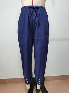Dettaglio dei pantaloni blu navy in cotone e lino con bottoni alle caviglie e coulisse