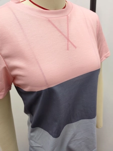 Detail of O-neck short sleeve T-shirt with pink and grey color-block patchwork and cross-stitch
