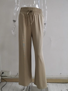 Dettaglio di pantaloni kaki a gamba larga a vita alta con elastico in vita e cordoncino