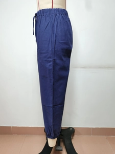 Dettaglio dei pantaloni in cotone e lino a vita alta con coulisse e tasche laterali cargo